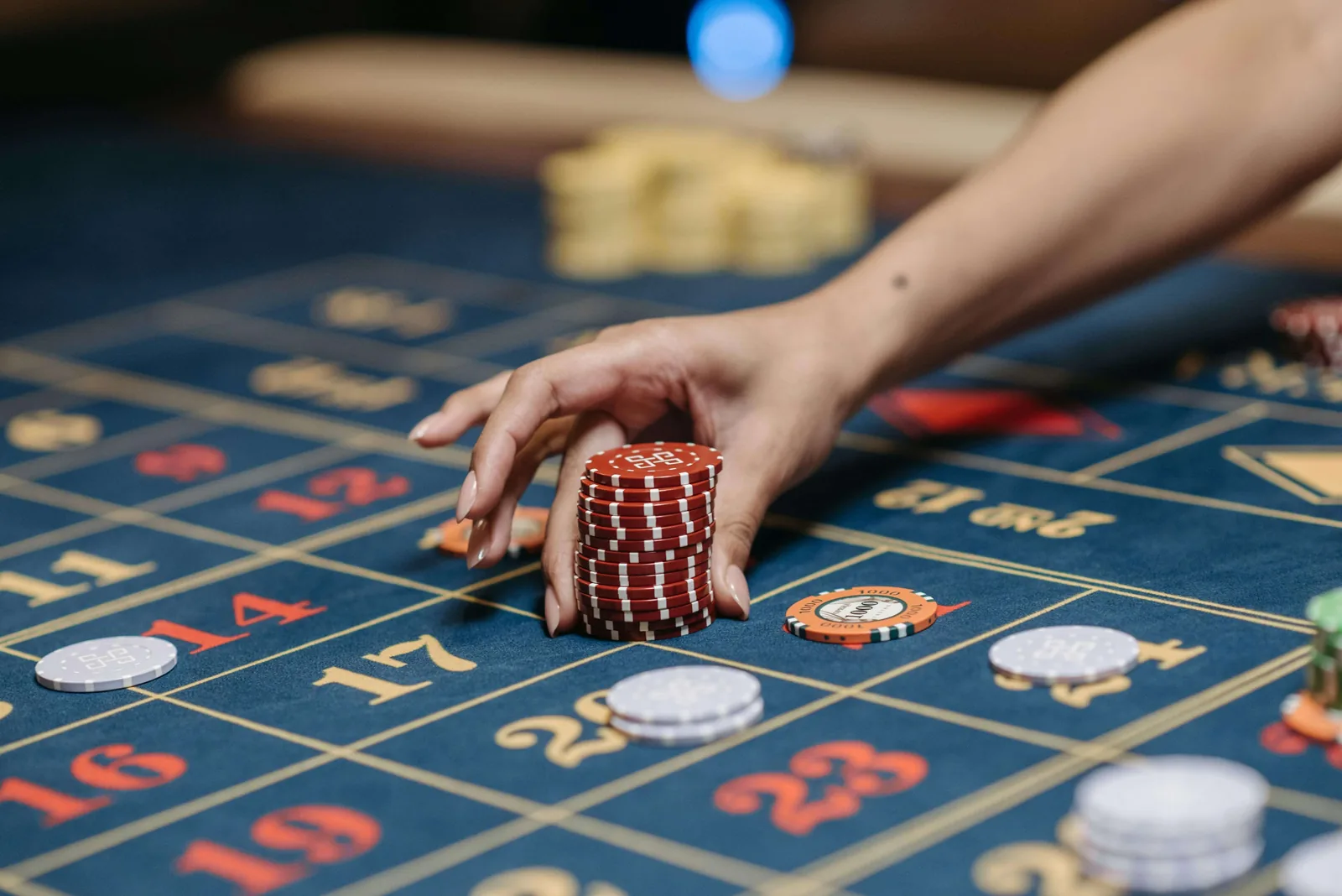 A dealer placing chips on a navy Velvetine roulette layout